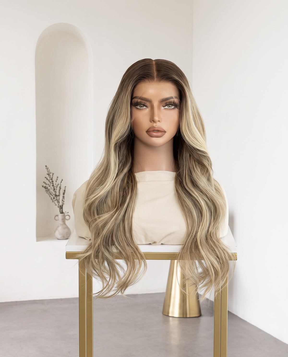 Yasmin rooted blonde body wave wig on a display stand