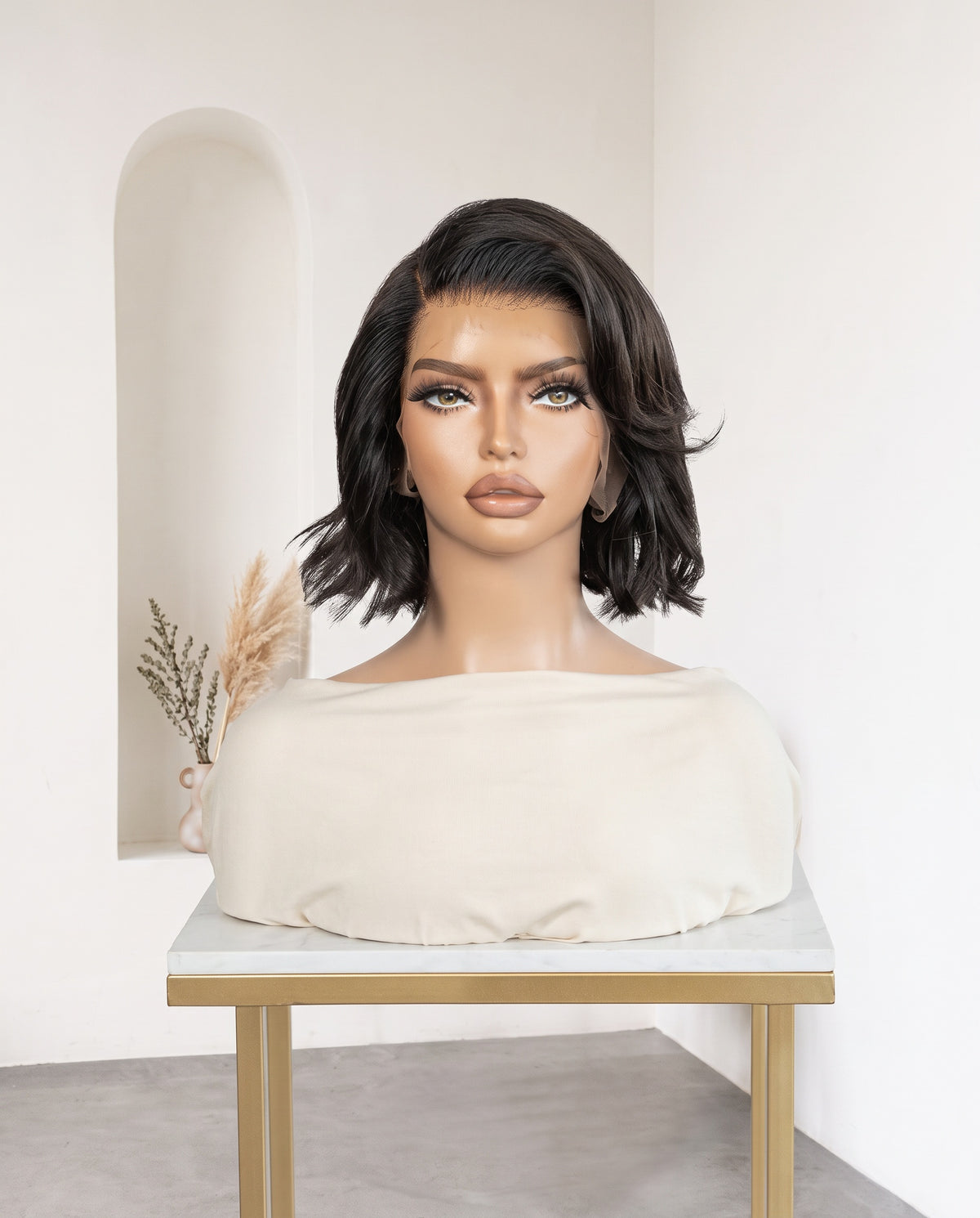 Naomi natural black wavy bob wig on a display stand